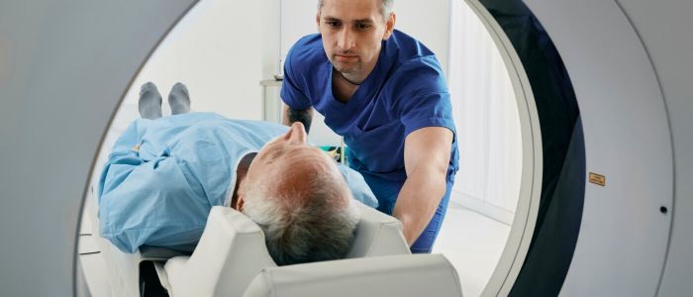 Doctor helping a patient into a CT Scanner