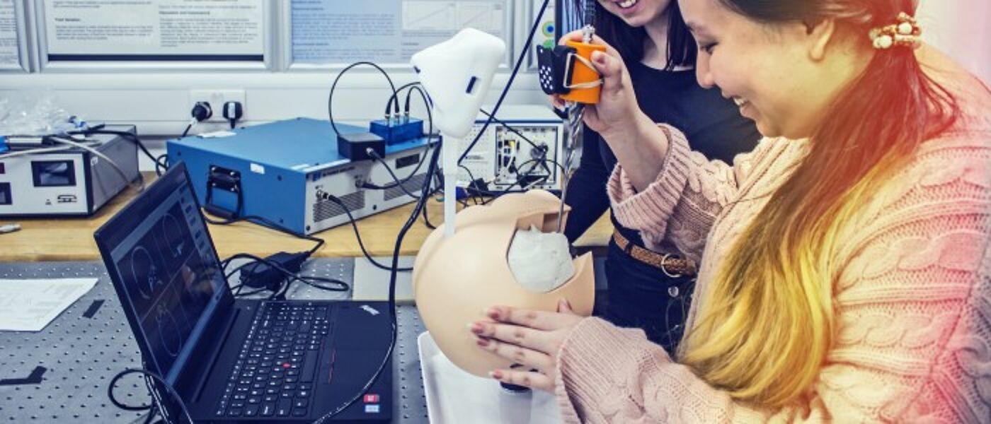 Two people use a surgical practice dummy to test a new skull drill