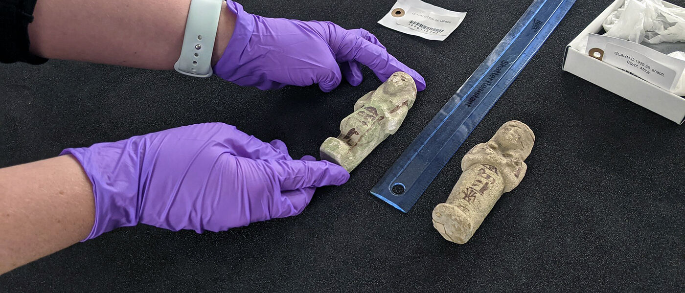 Shabti figures measured against a ruler