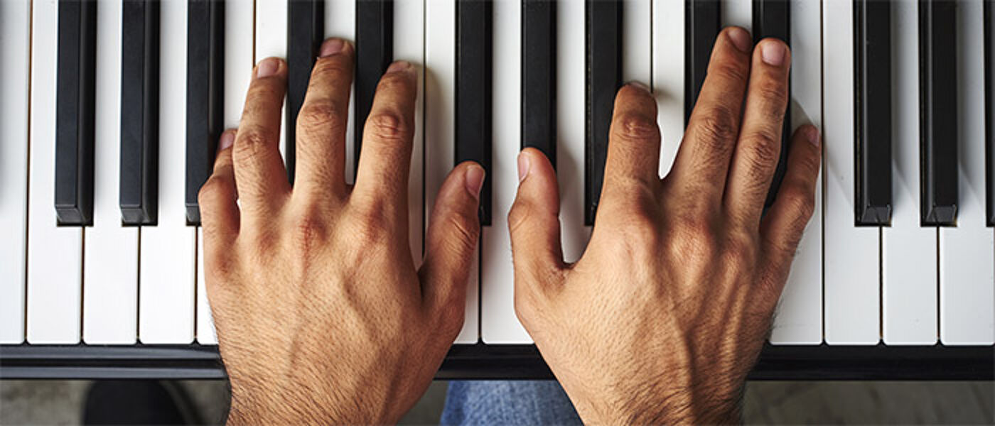 Hands on a piano keyboard