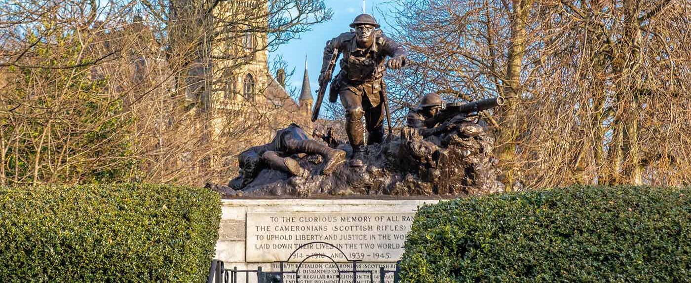 A war memorial in front of the University of Glasgow with the University Tower in the distance.