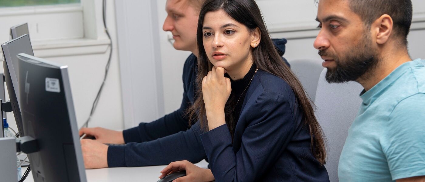 Three computing science students using computers