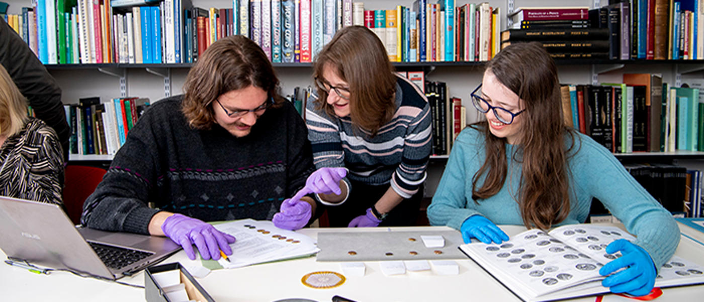 Students handling ancient coins