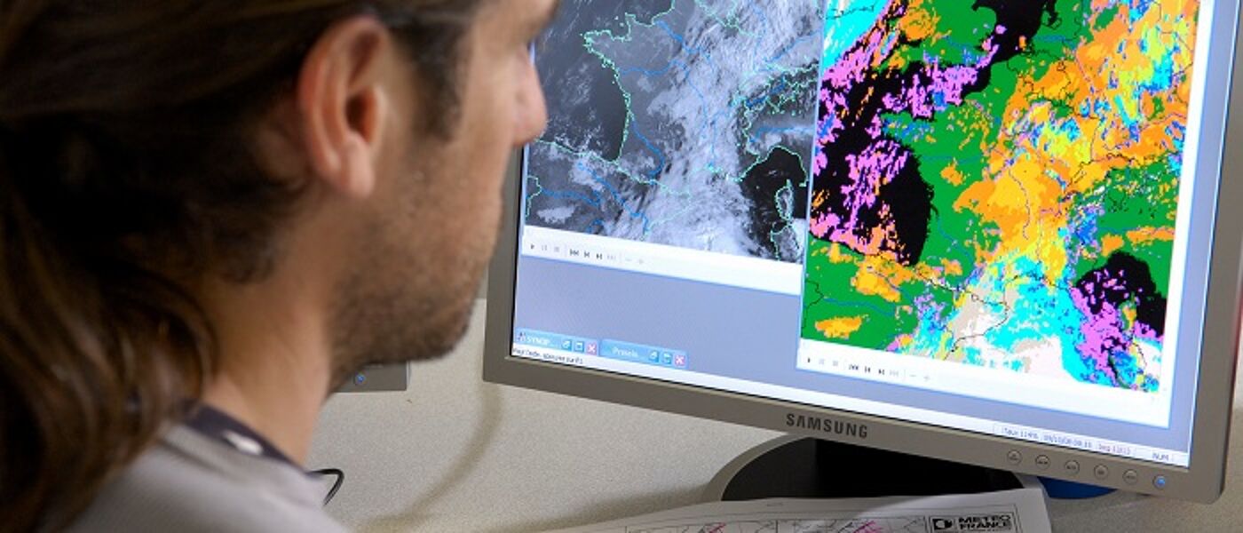 Student looks at computer screen with maps on it
