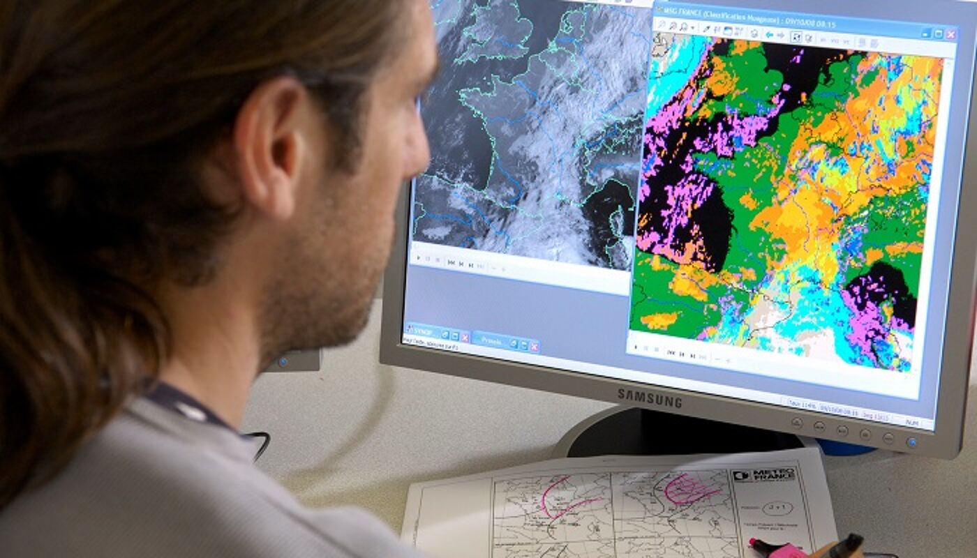 Student looks at computer screen with maps on it