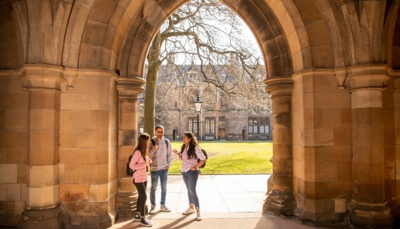 Students standing under the arch at the main building quadrangle