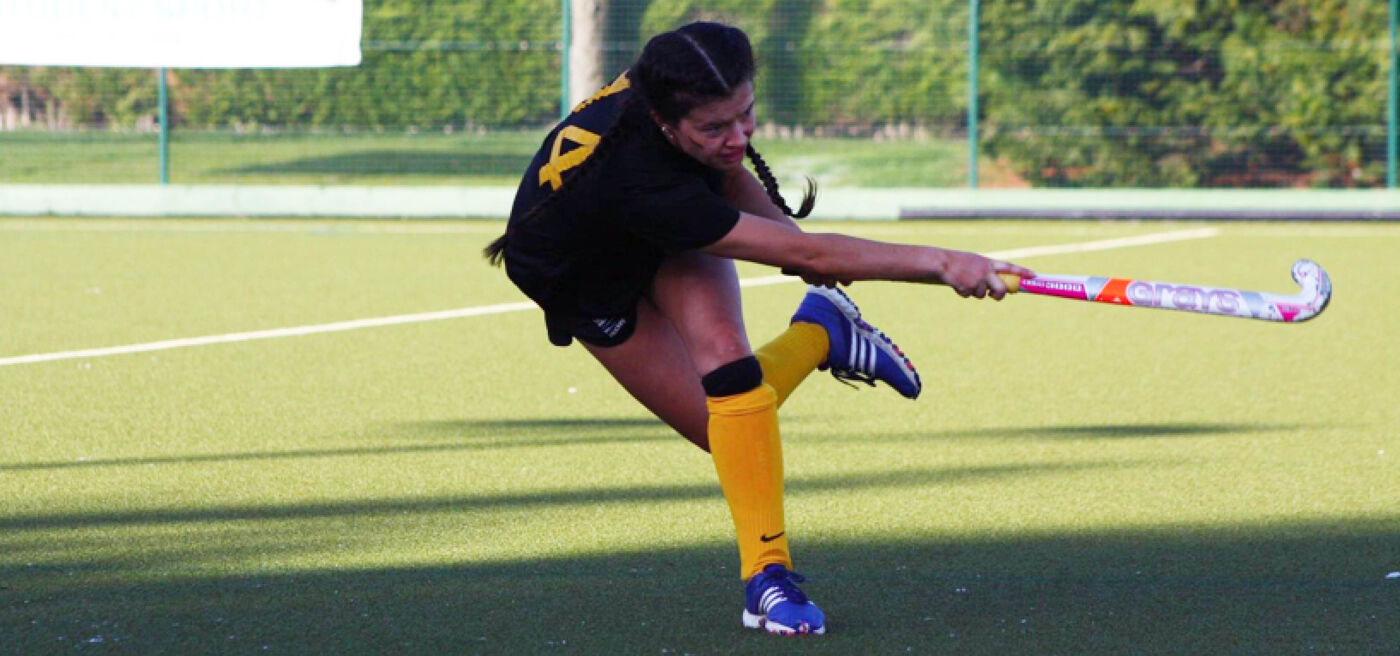 Women hockey player striking the ball