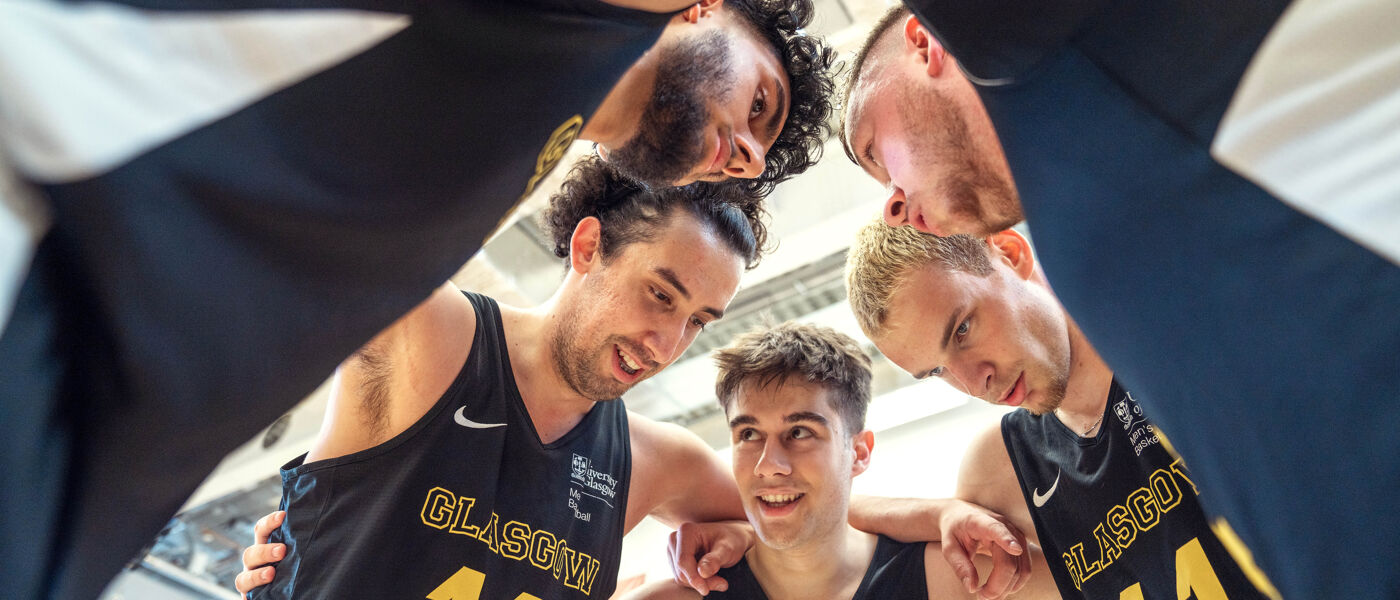 Mens Basketball team in group huddle