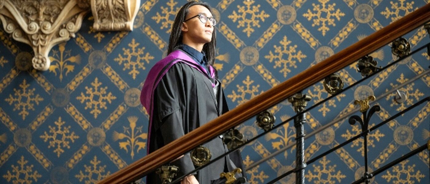Student in graduation robe on stairs