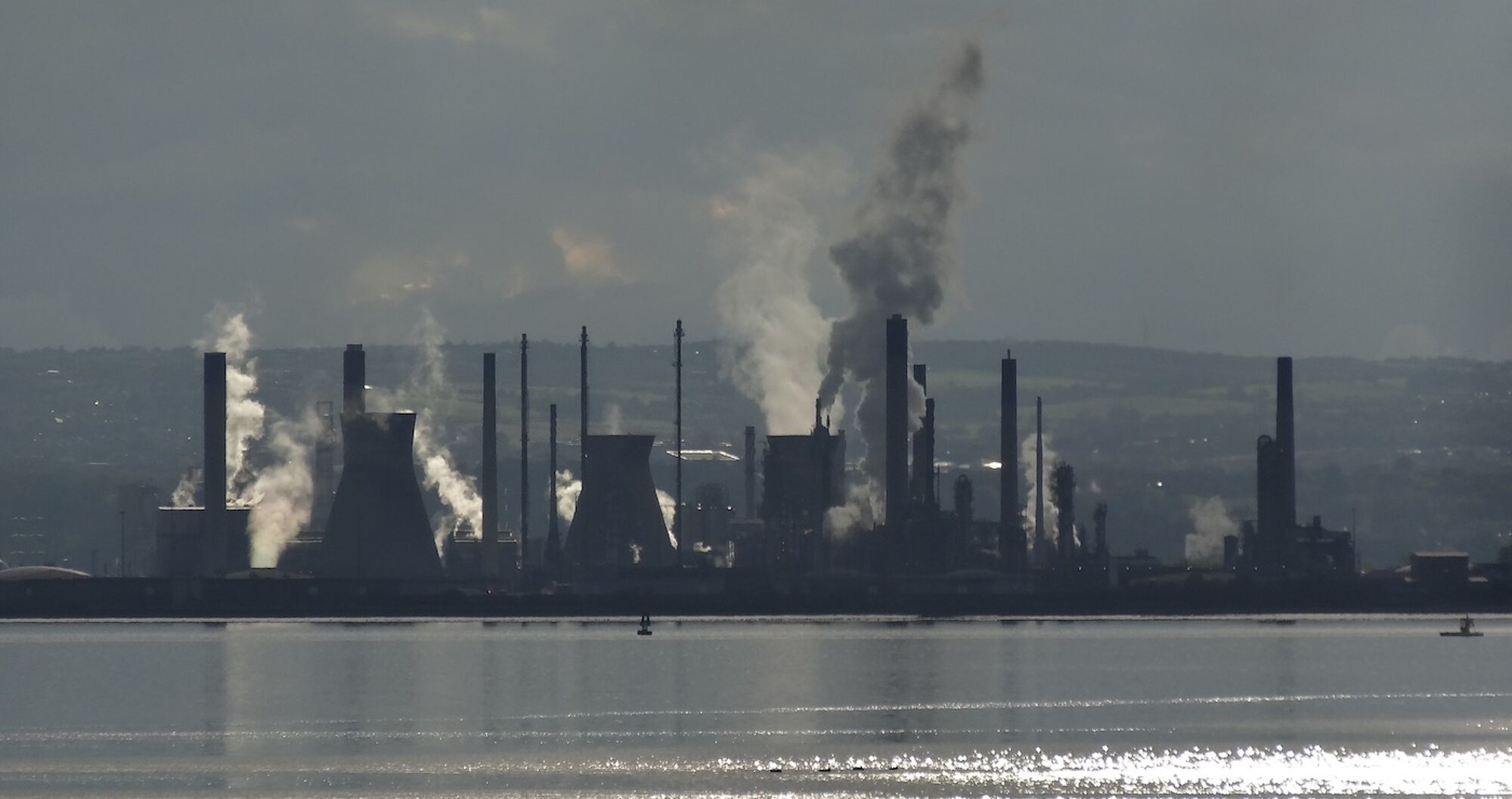 View of Grangemouth oil refinery across the Firth of Forth with smoke asns steam coming from lots of different chimneys. Photo credit: Anne Ward, Flickr https://www.flickr.com/photos/ilike/18962645435/