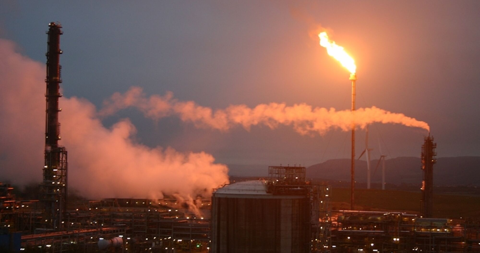 Mossmorran petrochemical plant at night with a large flare of fire erupting from a tall thin chimne. Crediet Alexnoel66 https://commons.wikimedia.org/wiki/File:Mossmorran.jpg