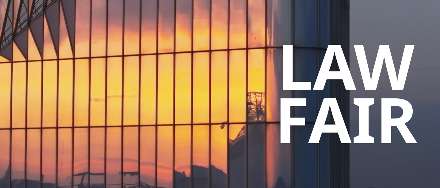 Sunset reflection on skyscraper facade with text: Law Fair