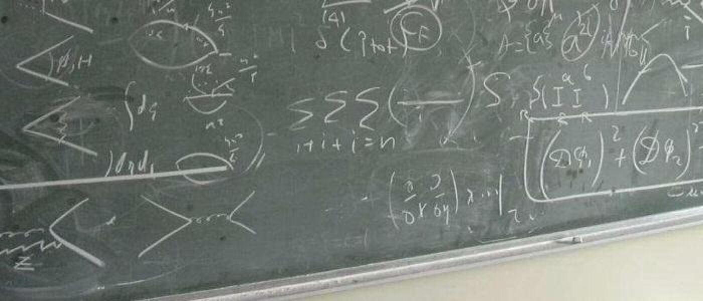 A banner image of the lower half of a chalkboard covered in equations