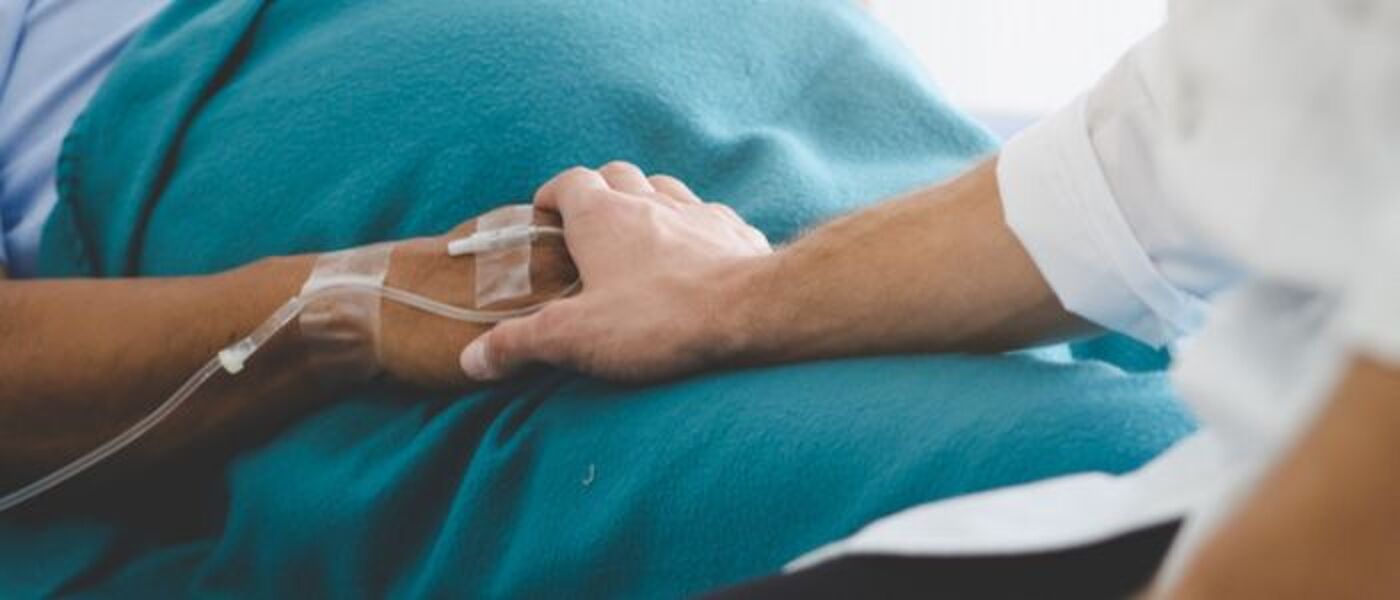 A healthcare professional holding the hand of a patient
