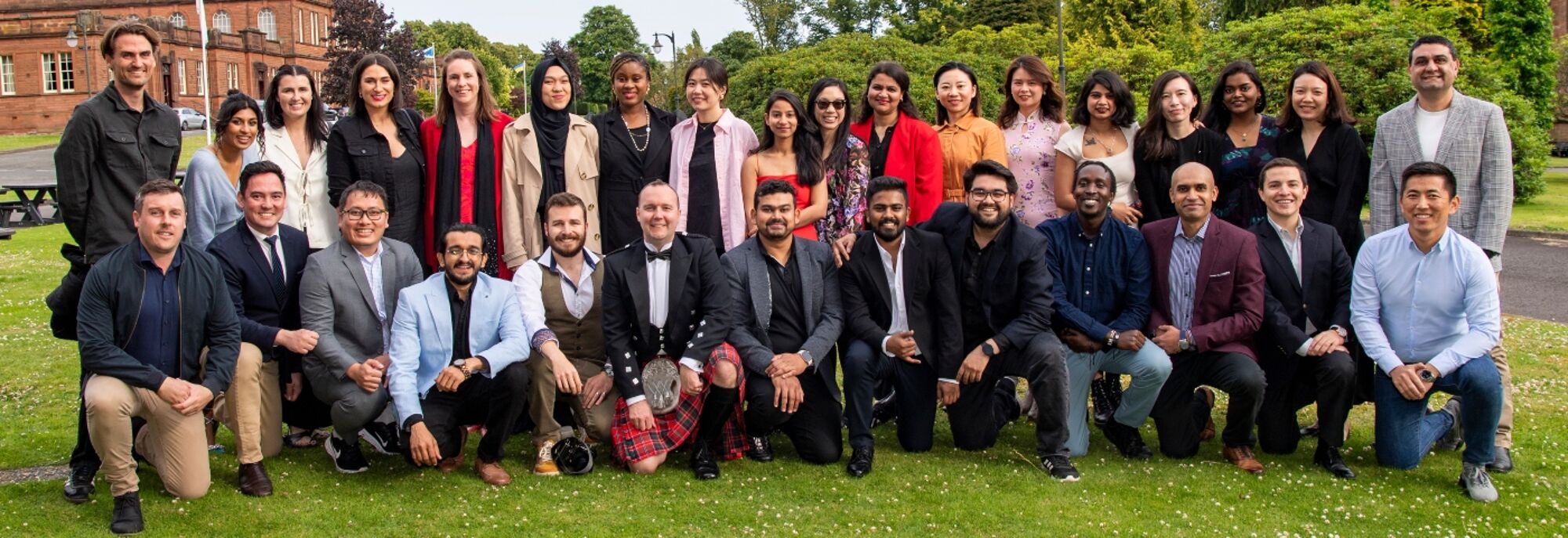 Students standing for a group photo on grass