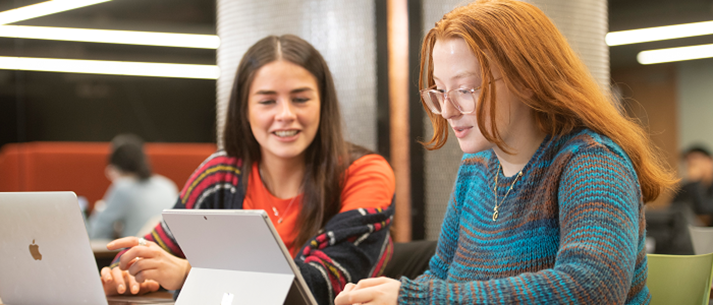 Two students looking at a laptop