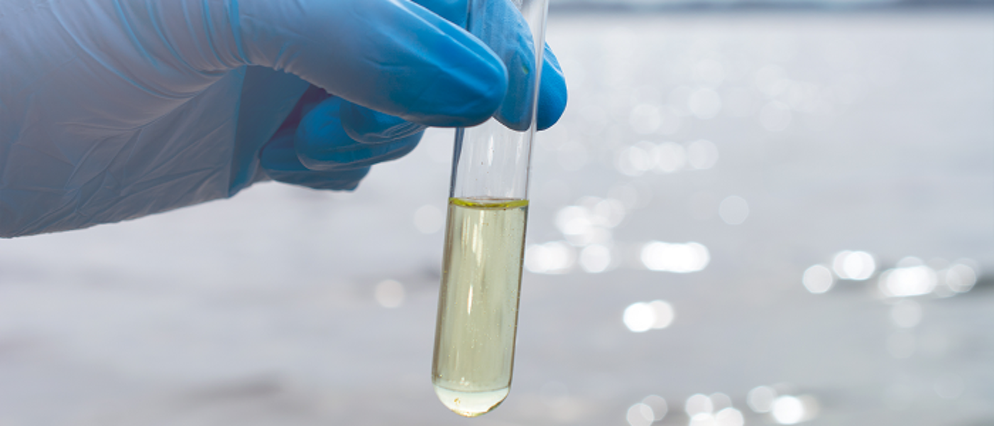 Blue gloved hand holding test tube
