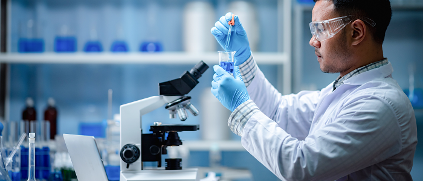 Student in lab with blue gloves and goggles