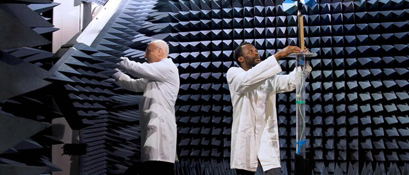 Two men in lab coats working on the antenna measurement system