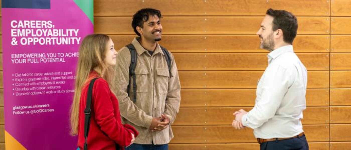 Two students speaking to an employer at a networking event in the Wolfson Medical Building