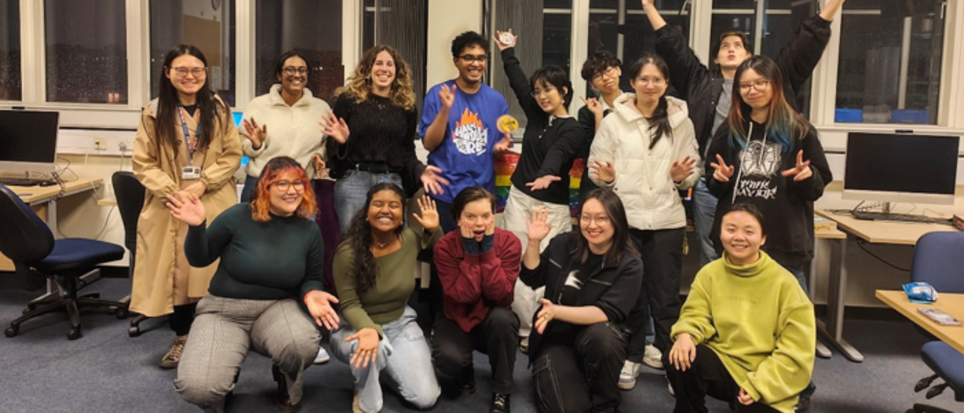 A group of students and staff posing for a group photo at a Rainbow Hours session