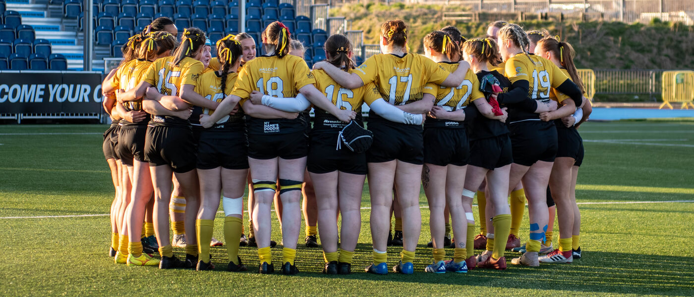 Glasgow Womens Rugby team in a huddle