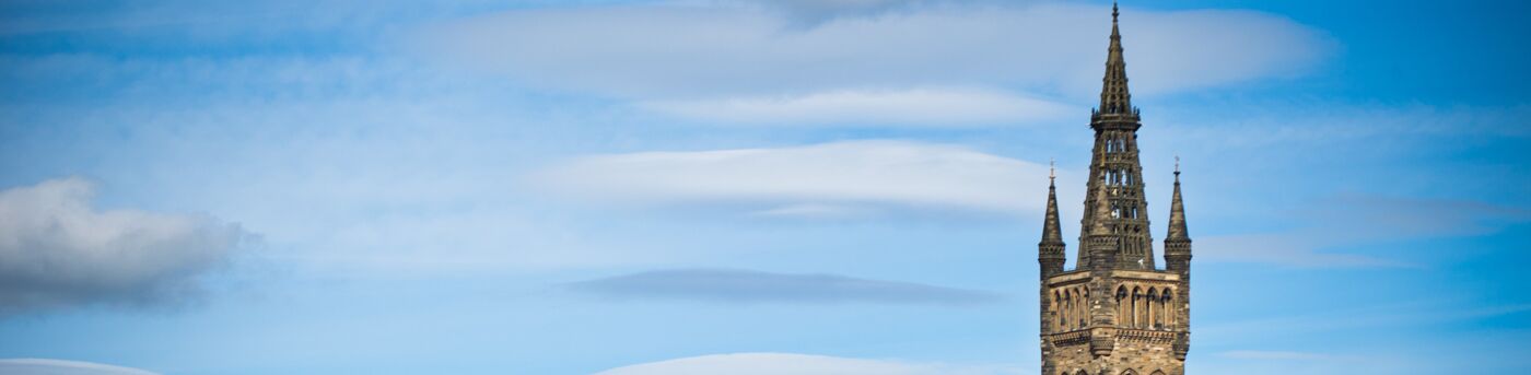 view of the top of the university tower against blue sky