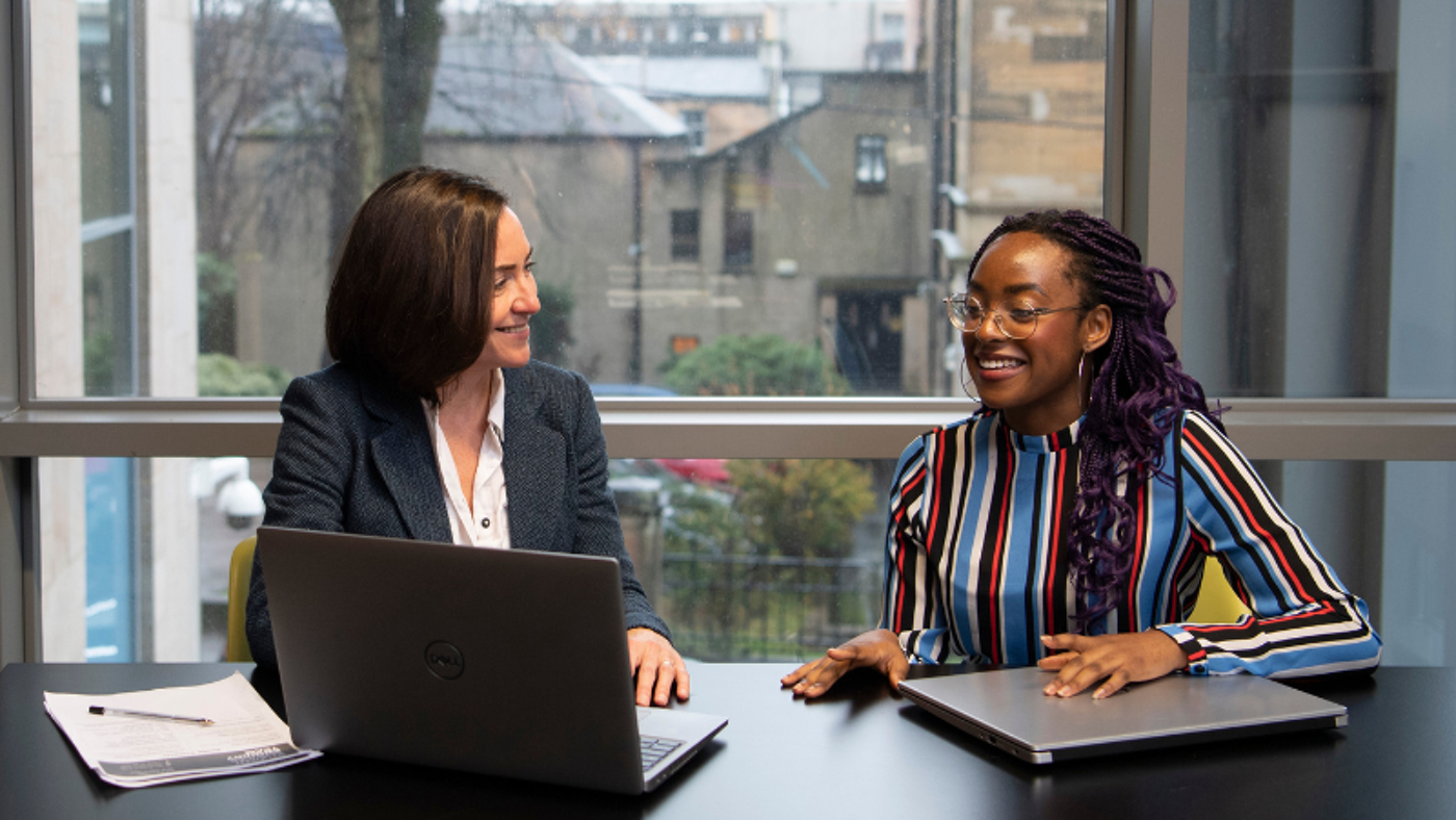 A member of staff from Student Services interviews a student.
