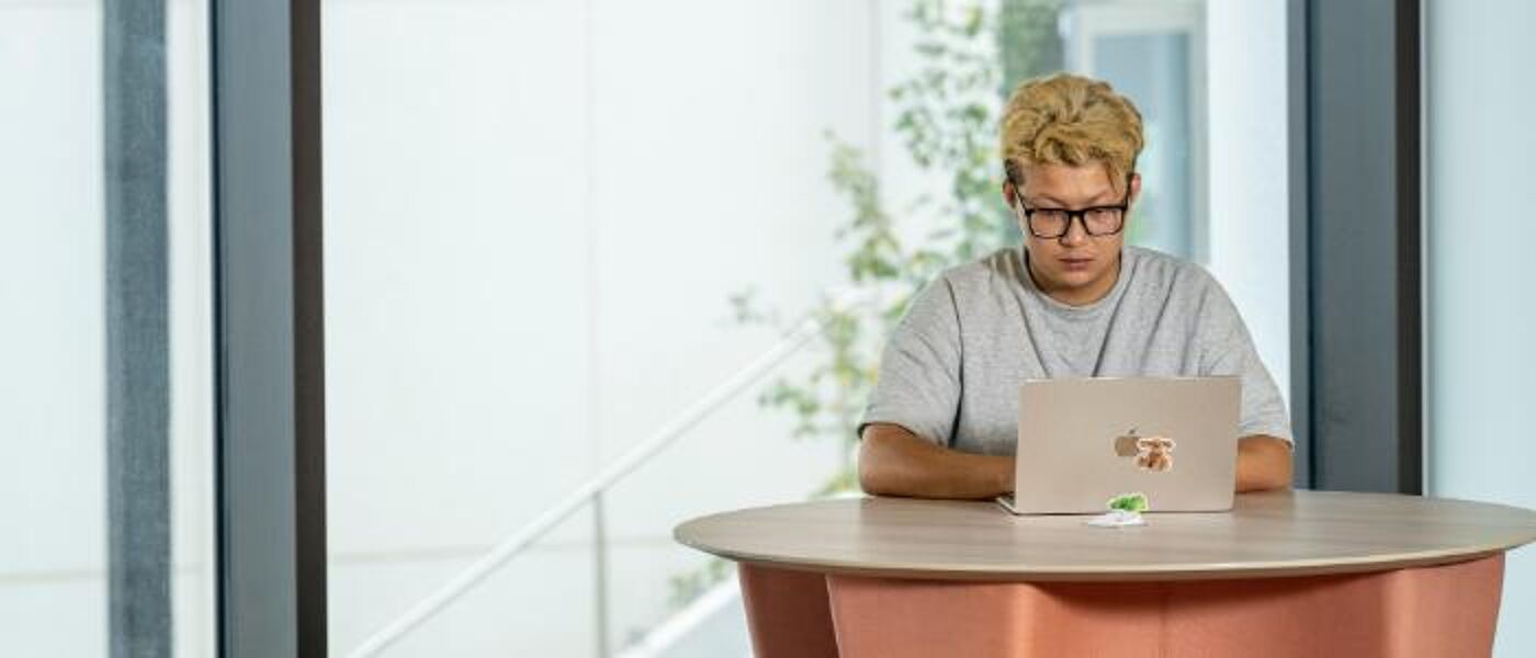 Student sitting with laptop in Adam Smith Business School Postgraduate Hub