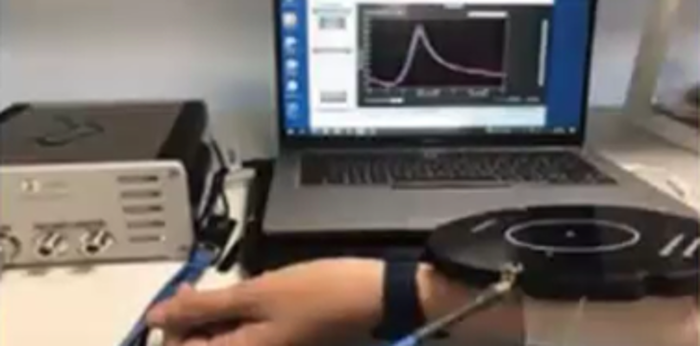RF sensing for healthcare: person's arm being monitored, with graph showing on a computer screen