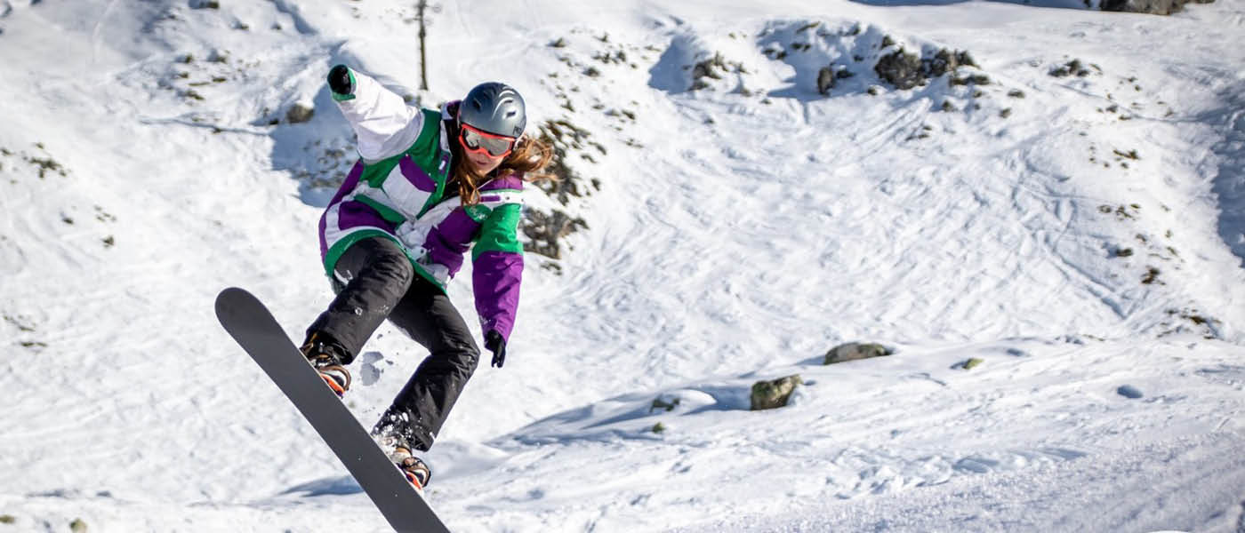 Student performing tricks on a snowboard