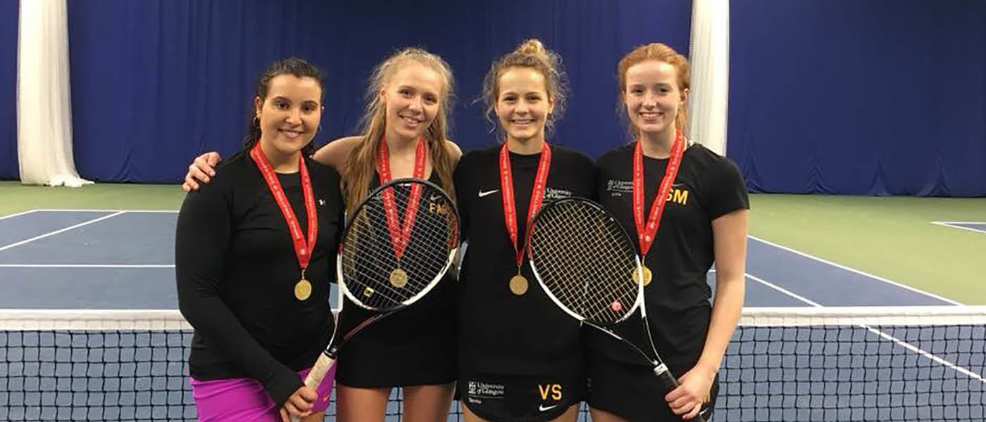Four students posing for a photograph after a tennis match