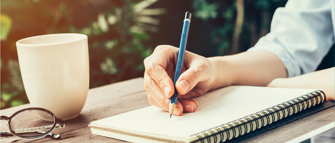 Person writting on notepad