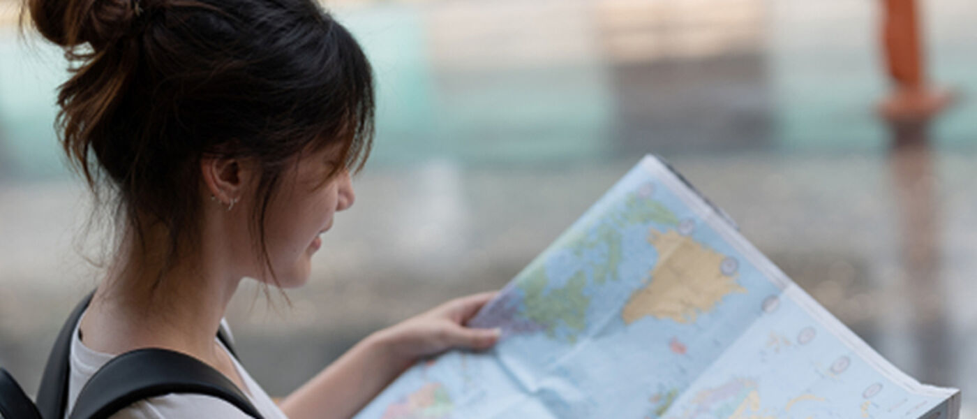 Student reading a map while travelling