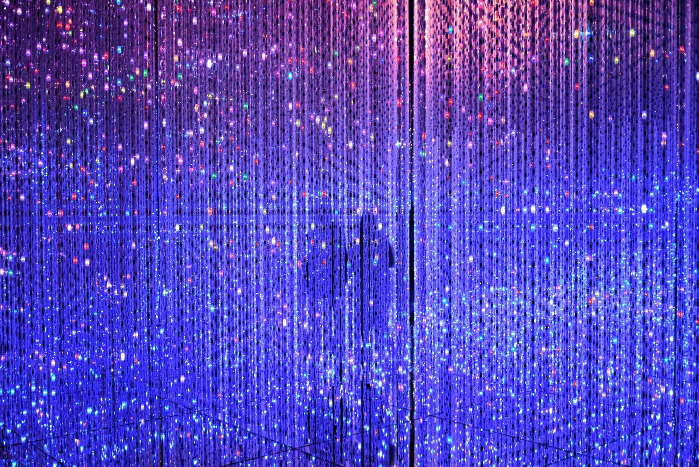 Two human figures behind a curtain of blue light