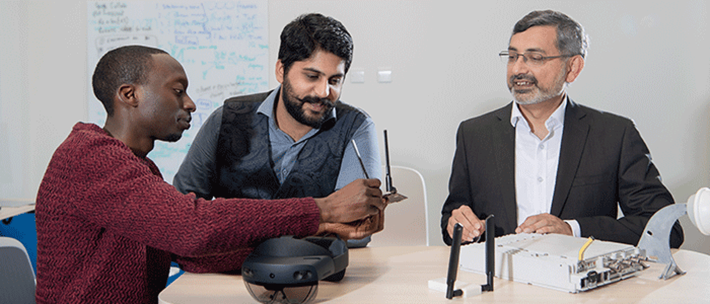 Three men looking at VR equipment