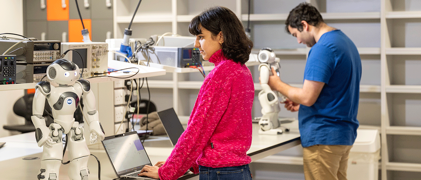 Students in a robotics lab programming small robots