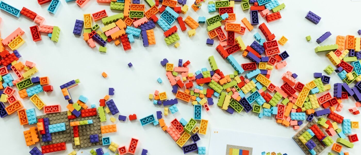 multicoloured lego bricks scattered across a white table