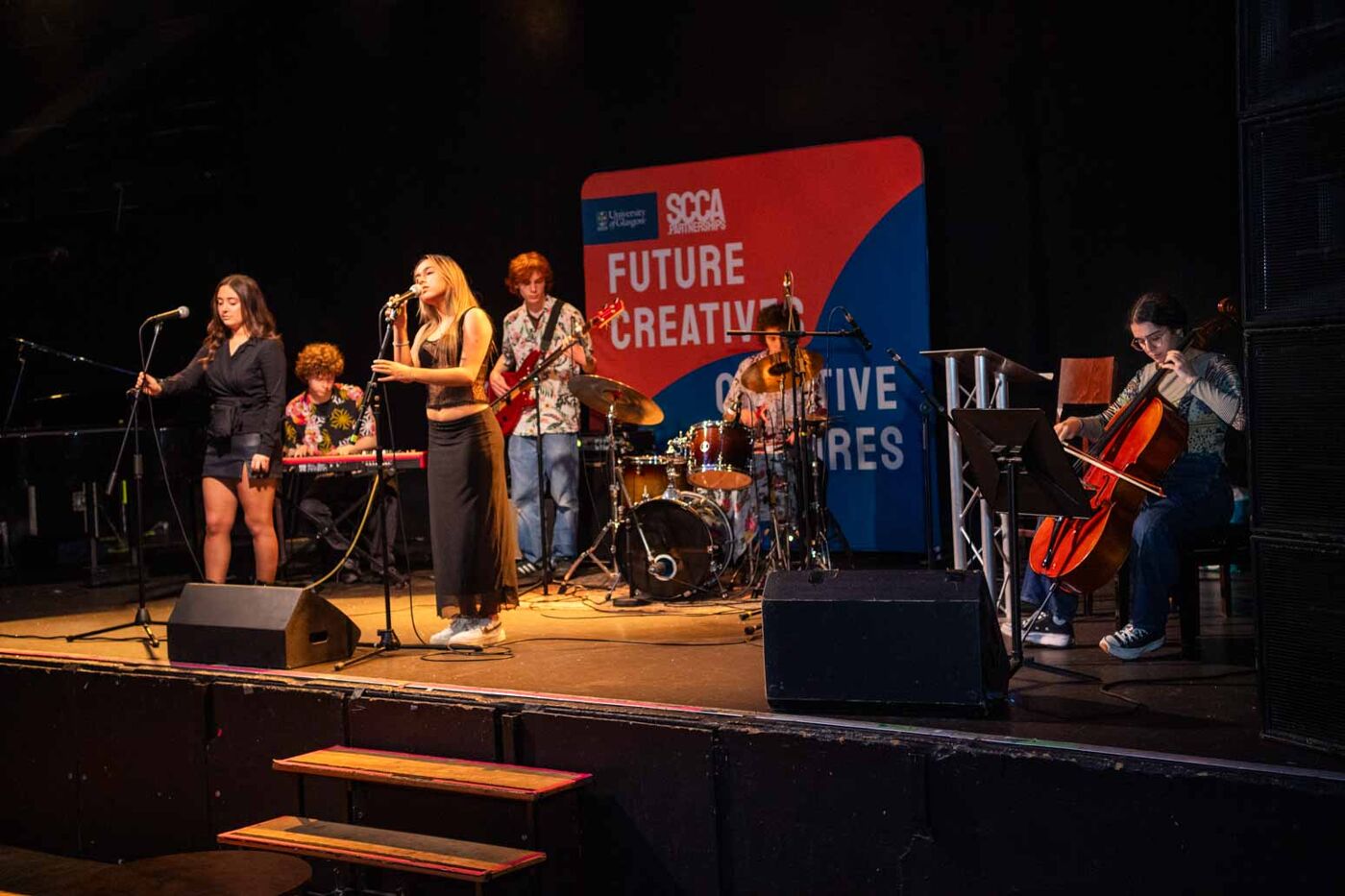 a band playing music on a stage in QMU