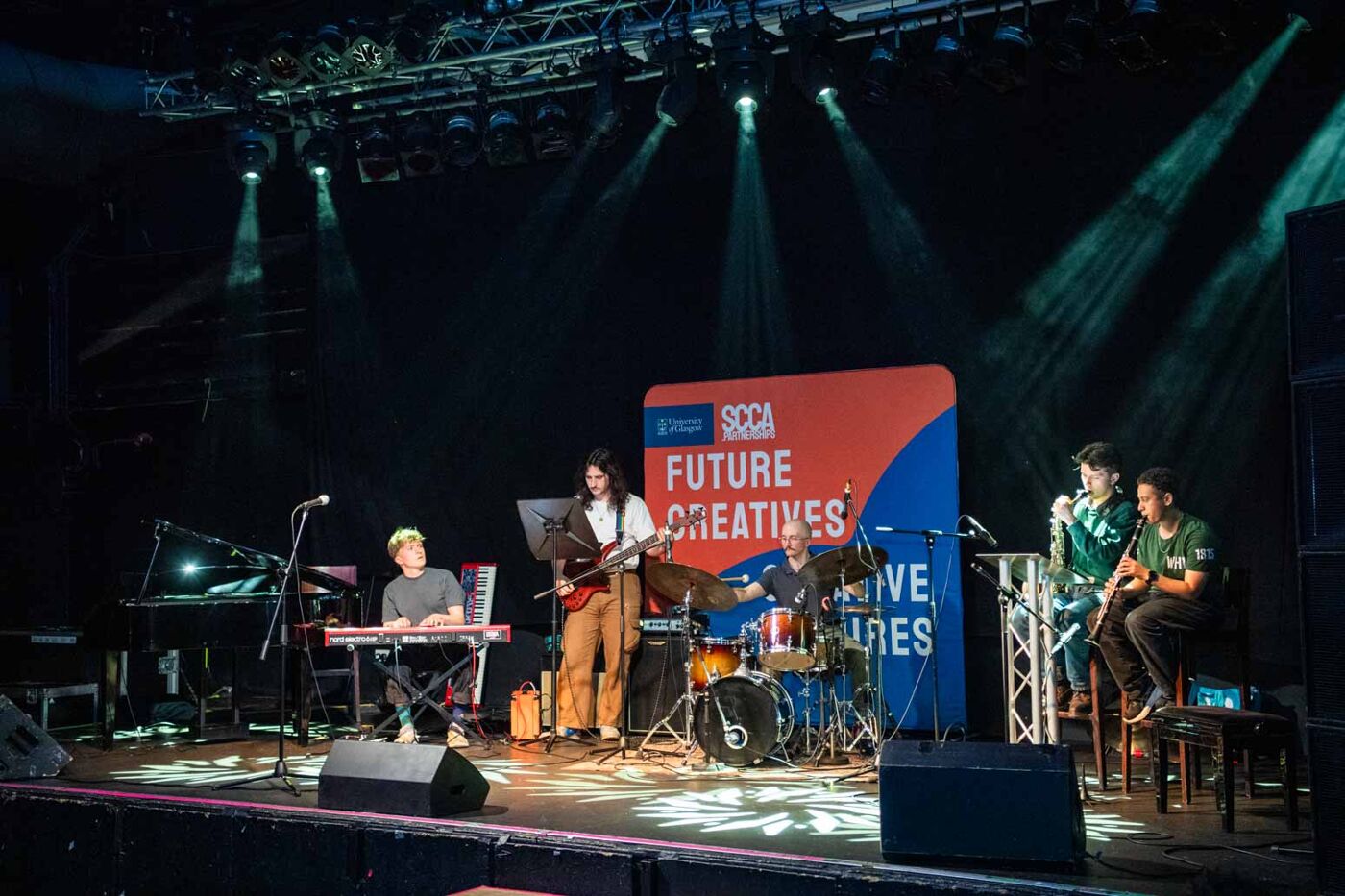 a band playing music on a stage in QMU