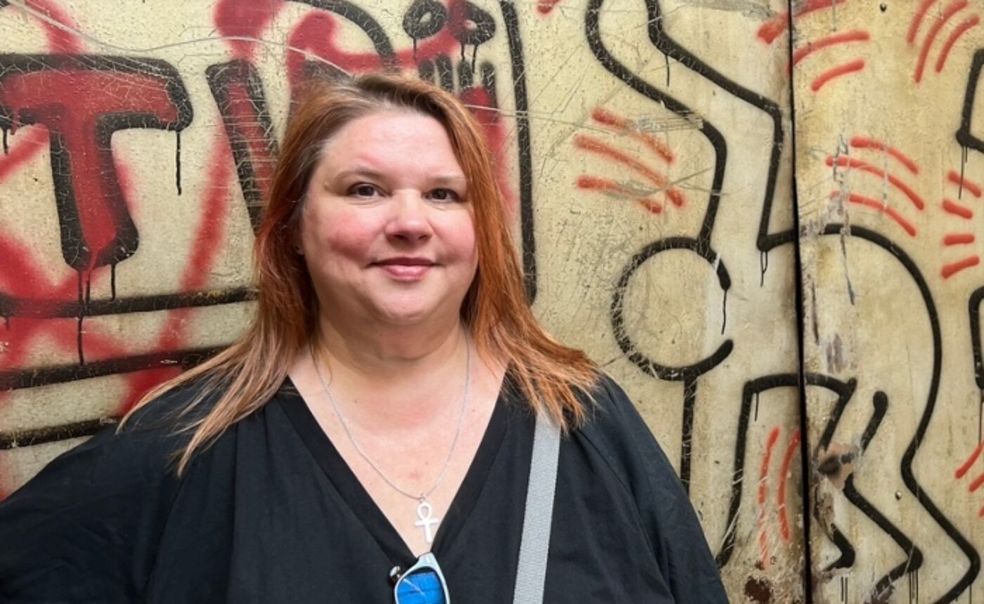 Profile photo of Dr Robyn Calvert standing in front of a graffitti wall