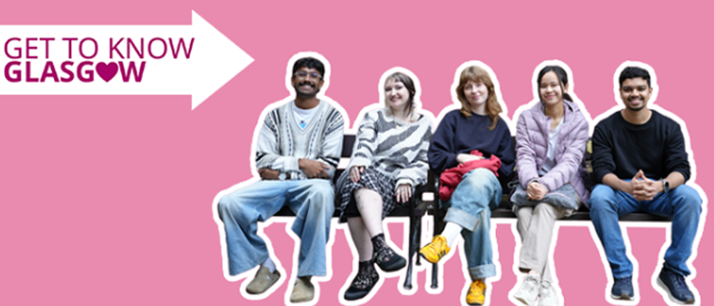 Five students smiling and sitting on benches