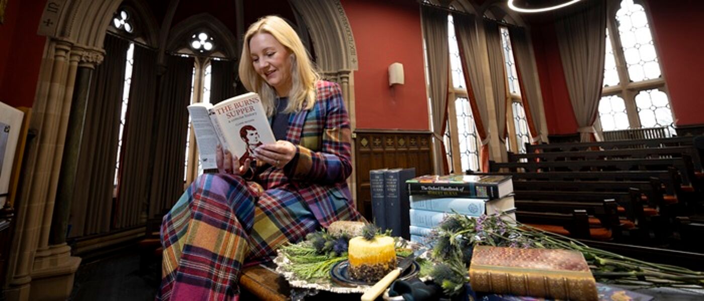 Professor Pauline Mackay in UofG's Humanity Lecture Theatre with Burns books and a Haggis