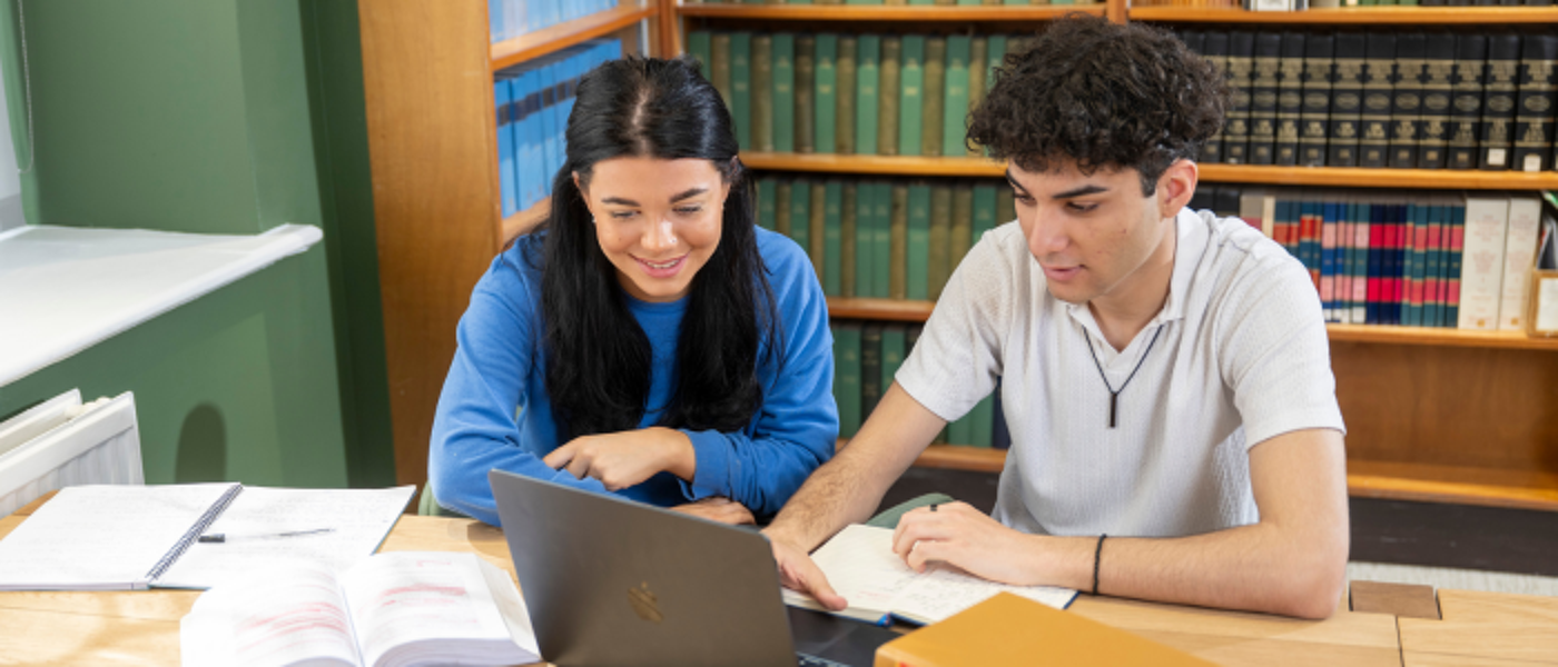 two law students in law library studying