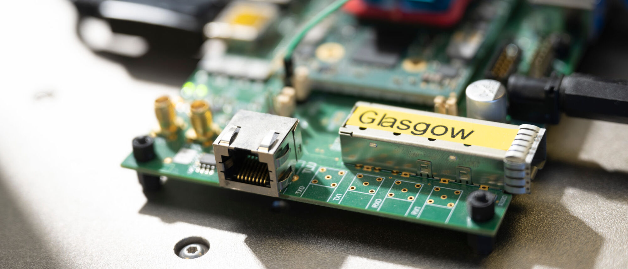 A close-up of a circuit board with the word 'Glasgow' prominently written on it