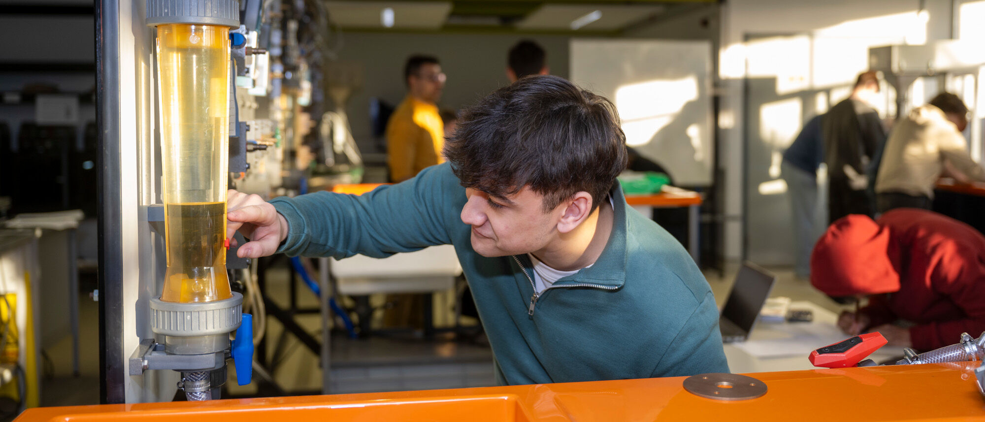 An engineering student examining equipment in a lab