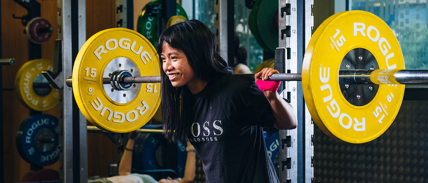 student lifting weights in UofG Sport gym