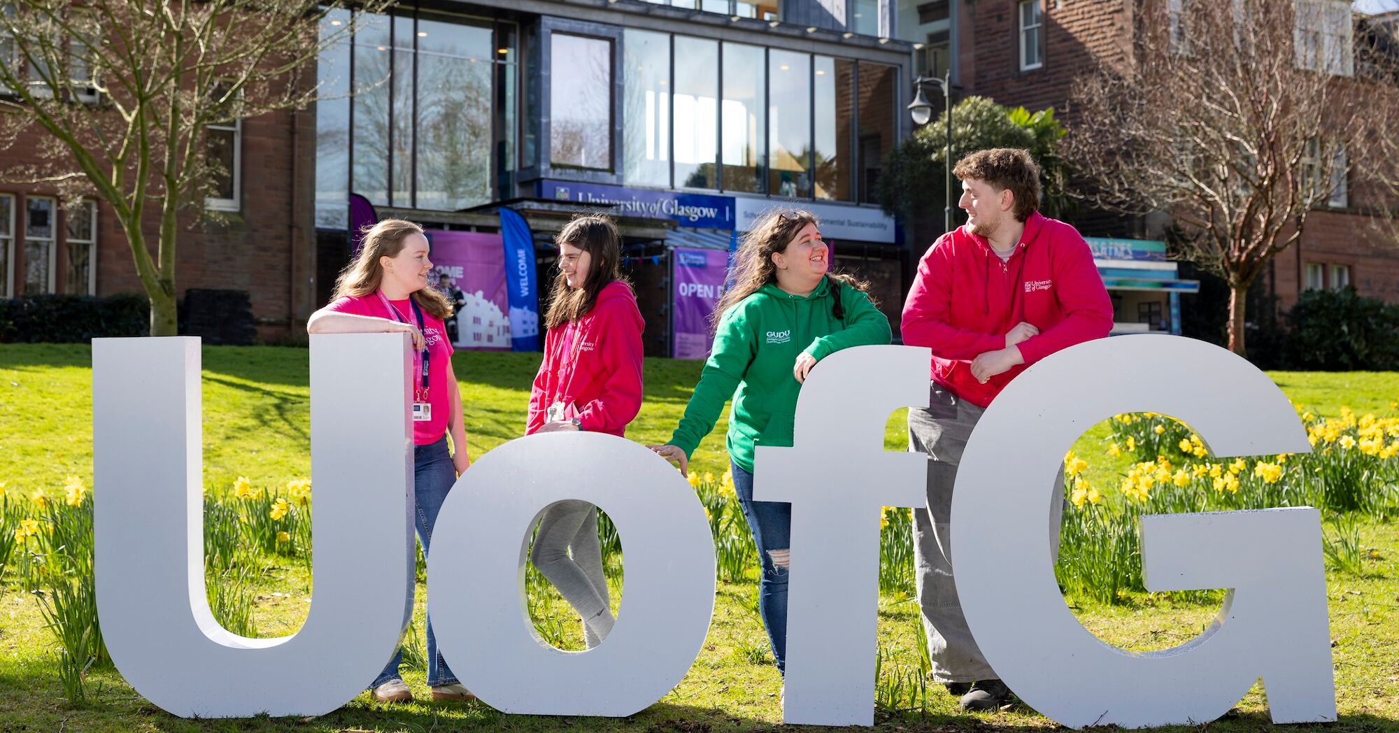 Four Dumfries Students Standing in Front of Large UofG Letters