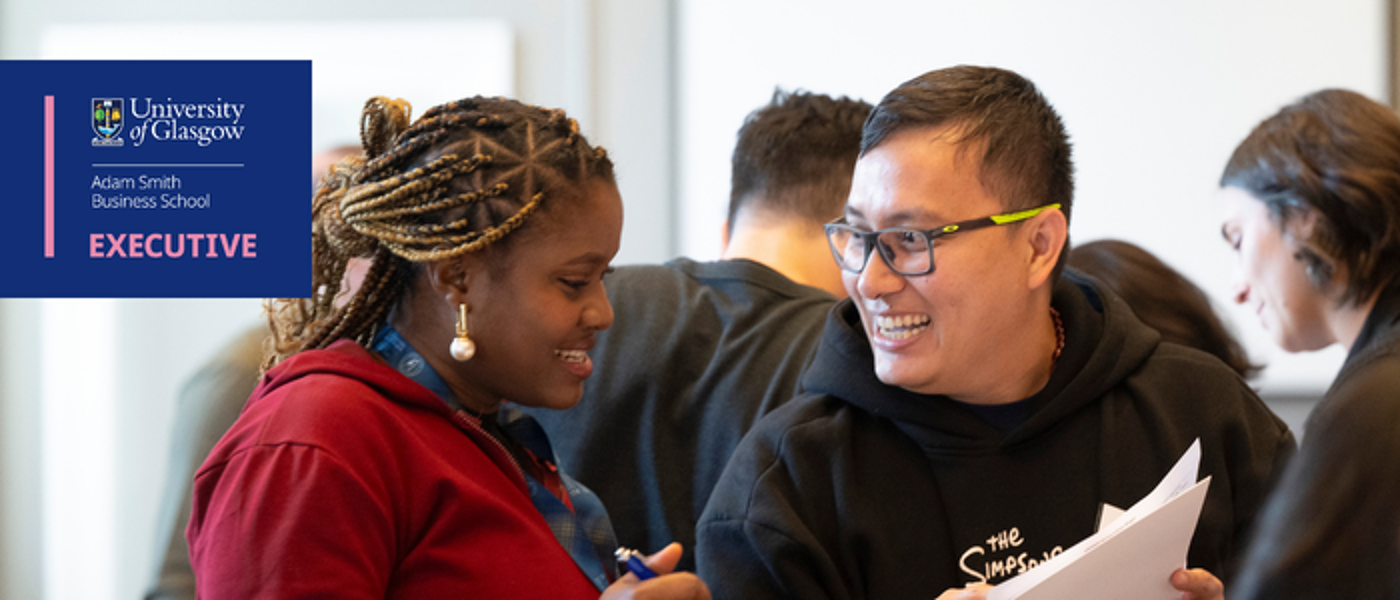 2 executive education attendees laugh during an icebreaker activity