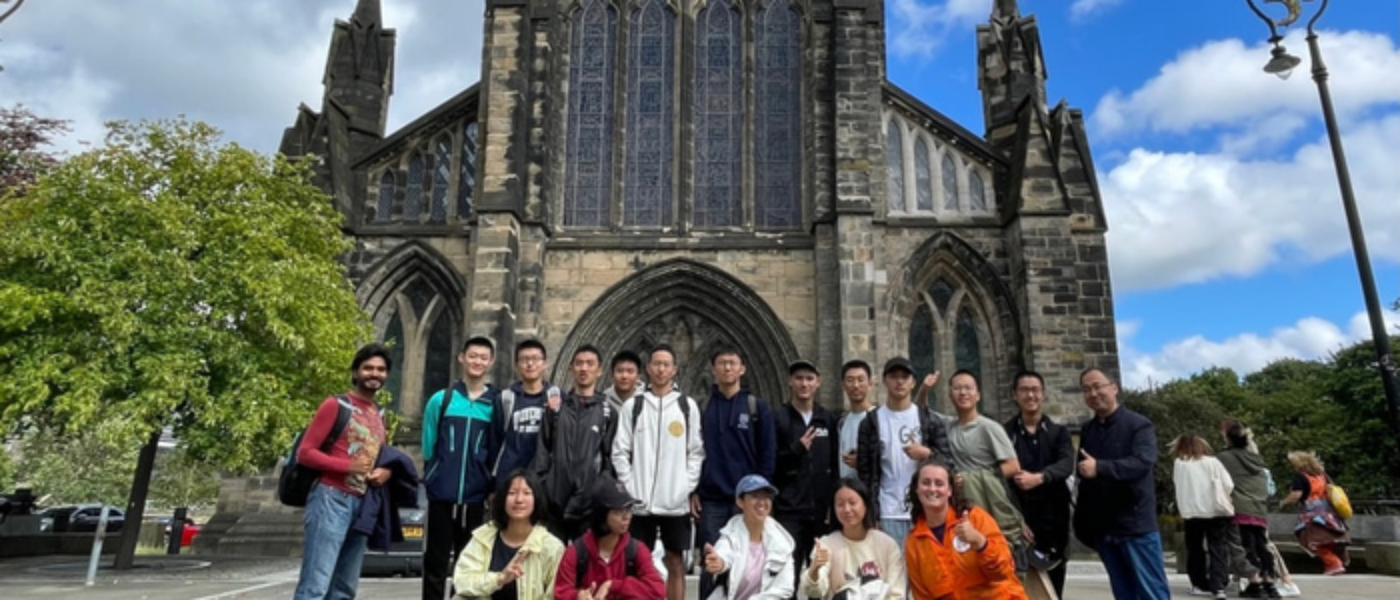 a large group of people pose in front of a Cathedral in Glasgow